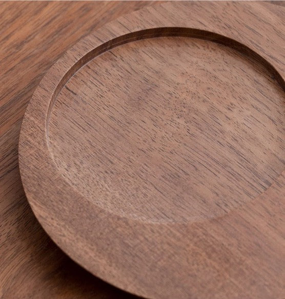 Close-up view of a handcrafted wooden plate showing its smooth texture and natural wood grain pattern.