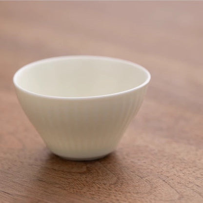 Elegant white teacup from the "Mr. Nanshan" Portable Tea Set on a wooden surface