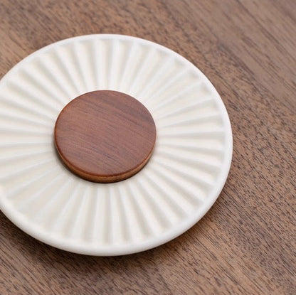 Elegant ceramic and wooden lid from the Mr. Nanshan Portable Tea Set displayed on a wooden surface.