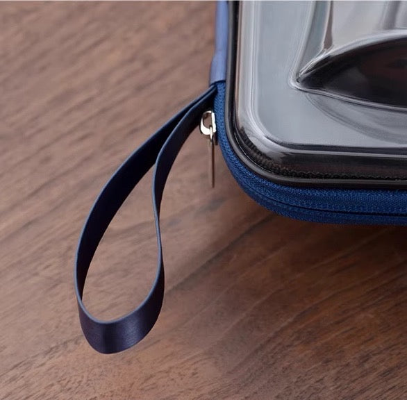 Close-up of Lotus Portable Tea Set's compact carrying case zipper and handle on wooden surface